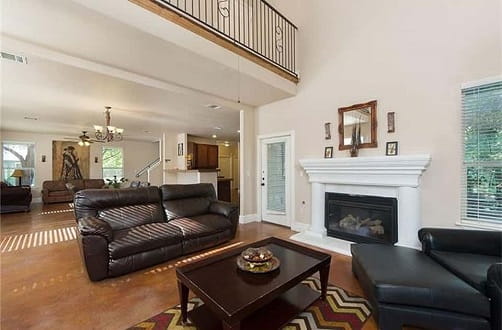 Inside view of Austin Sober Living home with elegant room in two story house with hardwoods, fireplace, and leather couches. 